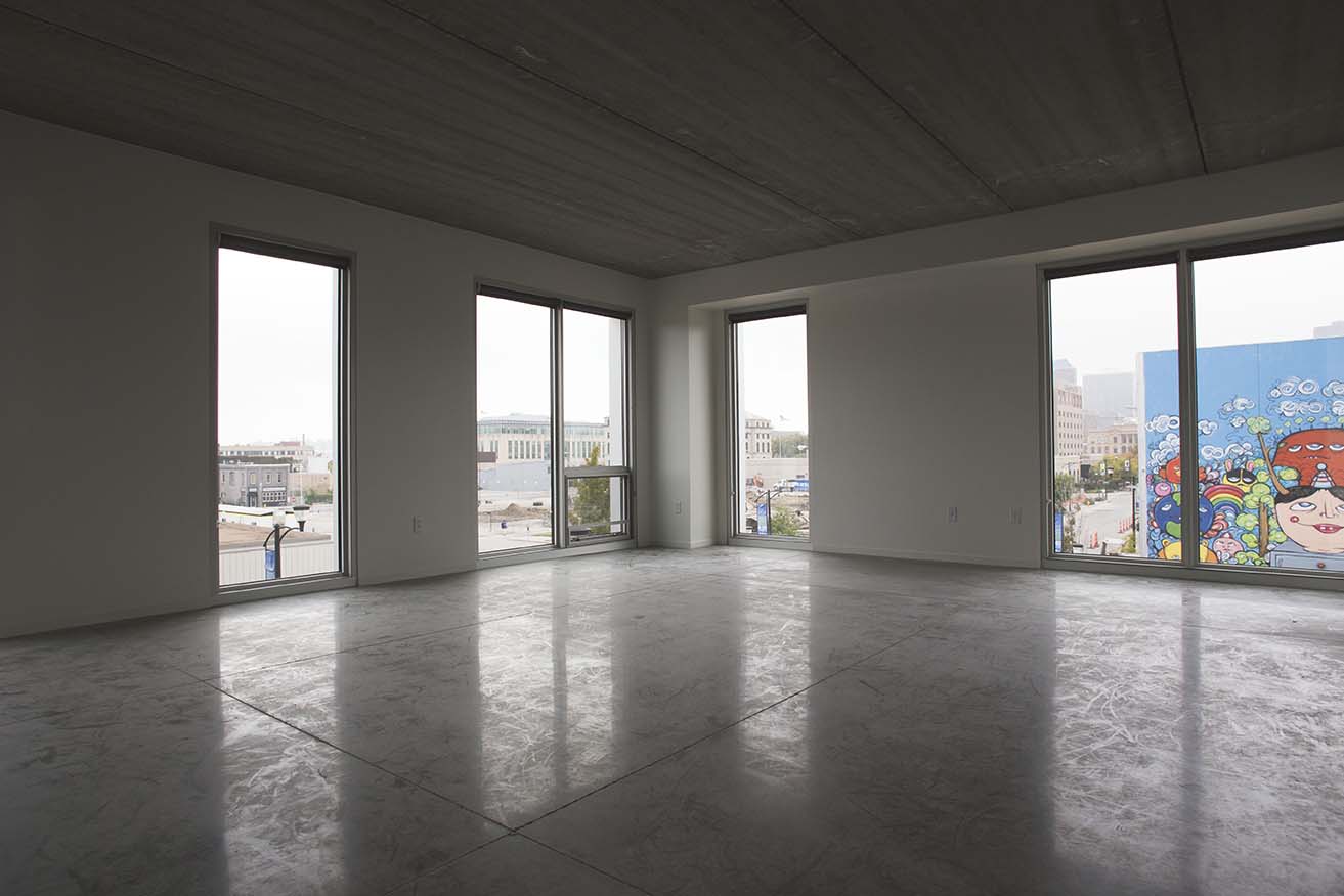 Interior image of wide open space looking out towards urban city scape.