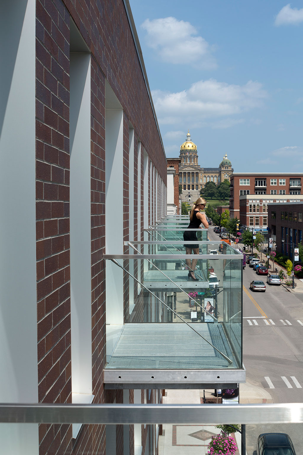 Exterior image detailing the columns of balconies, all with a view to the steps of the capitol.